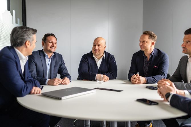 Mehrere Manager der Firma akquinet sitzen am Konferenztisch.