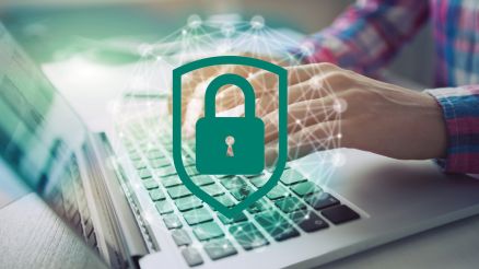 Ein Mann arbeitet an einem PC und ein Sicherheitsschloss ist als Grafik auf dem Bild platziert.