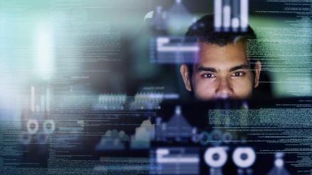 MDG bRobots Mann sitzt hinter Programmierbildschirm