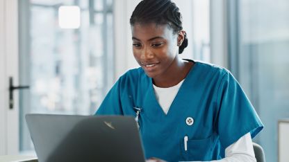 Eine junge Ärztin arbeitet an einem Laptop mit der ePA von AKQUINET