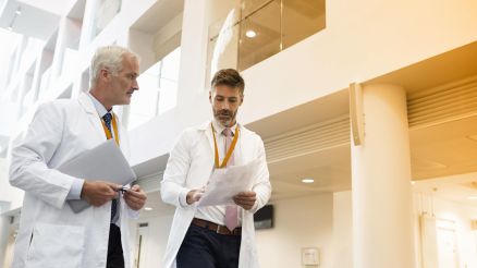 Zwei Ärzte diskutieren im Foyer eines Krankenhauses