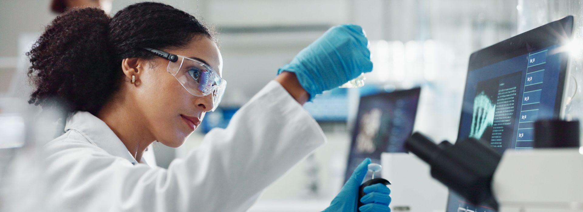 Eine Frau arbeitet in einem Labor mit Pipette und Reagenzglas