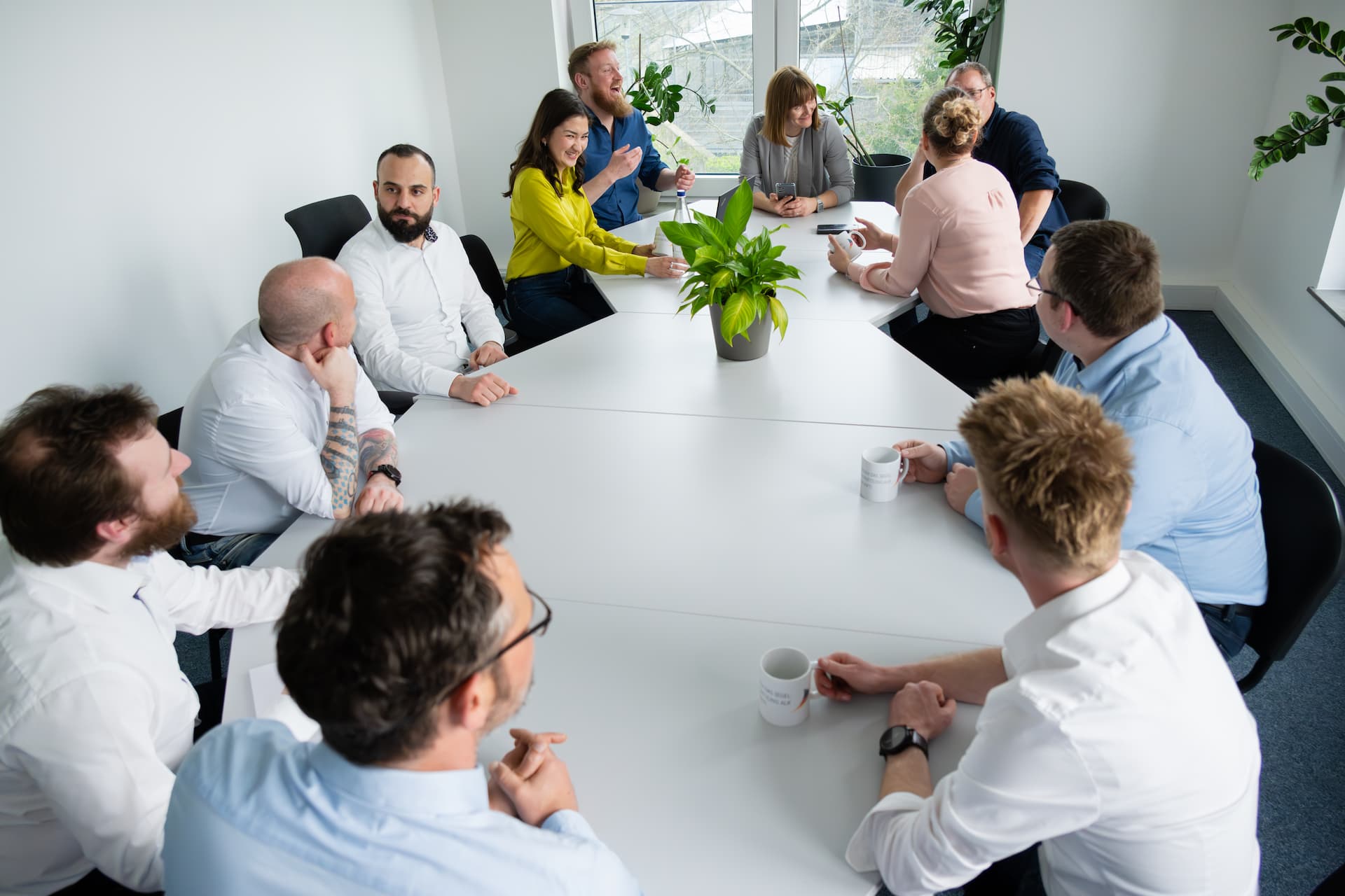 Menschen sitzen zusammen am Tisch und unterhalten sich.