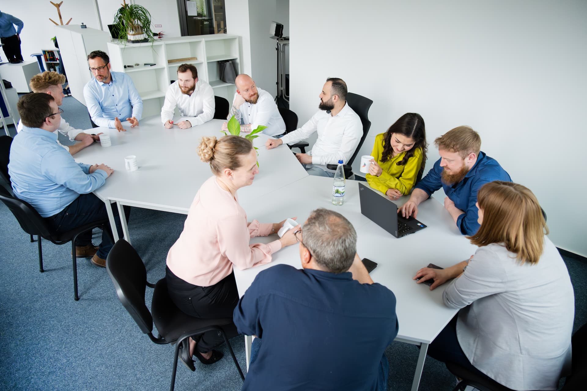 Menschen sitzen zusammen am Tisch und unterhalten sich.